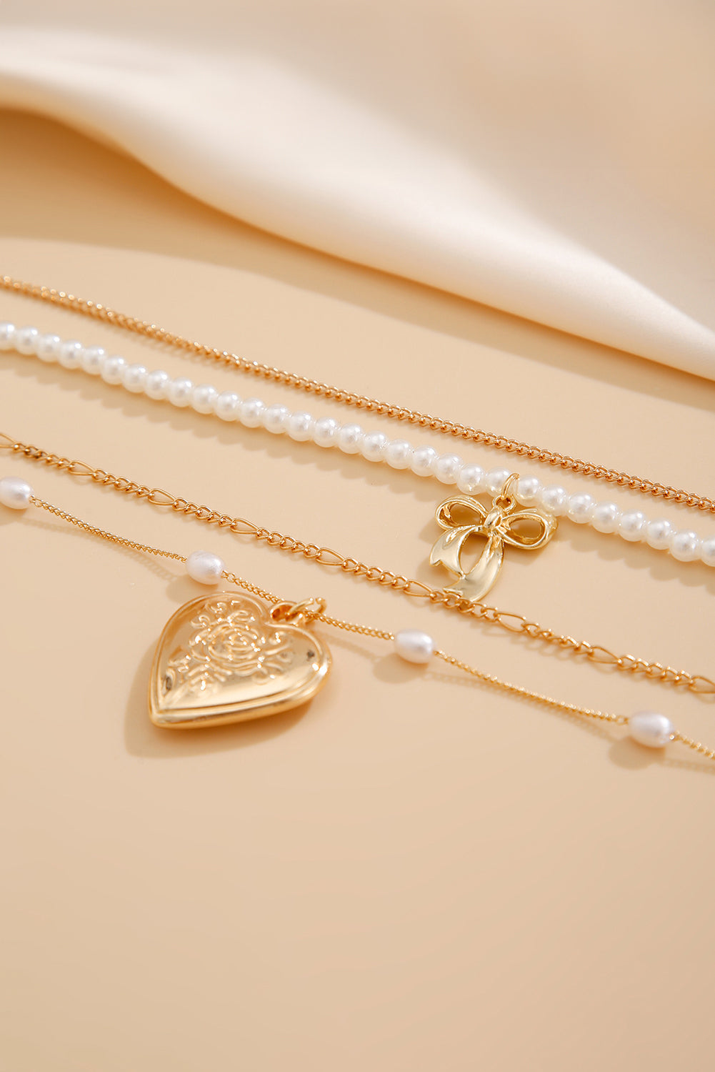 Multi-layer necklace with gold heart pendant and pearls